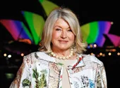 Martha Stewart in front of a litup architectural backdrop at night